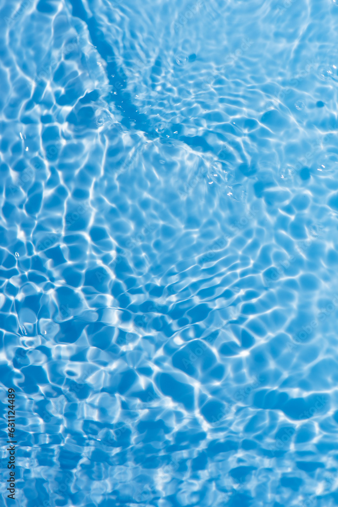 Obraz premium Blue water with ripples on the surface. Defocus blurred transparent blue colored clear calm water surface texture with splashes and bubbles. Water waves with shining pattern texture background.