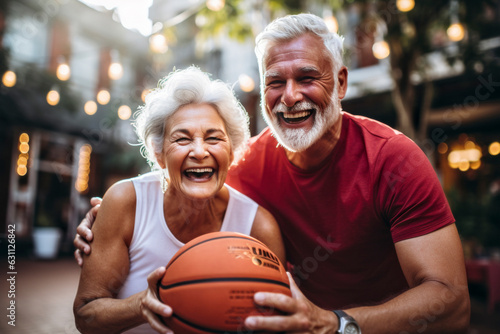 Happy eldery couple playing basketball together in the city. Elderly people and sport concept. photo