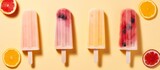 Top view of fruit popsicles on a stick. Fruit ice creams in different colors isolated on a flat pastel yellow background with copy space