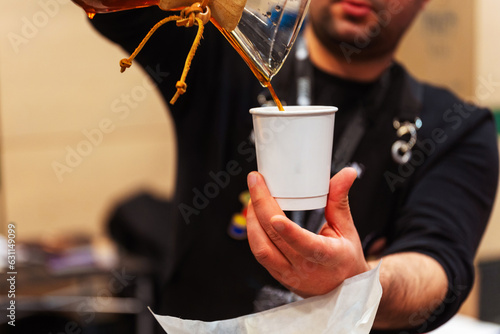 Photography a man brews coffee in a disposable cup