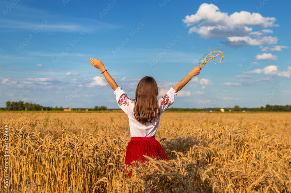 Ukrainian child in vyshyvanka in wheat field. Selective focus.
