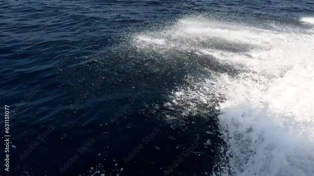 Slow motion wave trails sea foam on ocean moving speedboat Slow motion wave trails sea foam on ocean moving speedboat