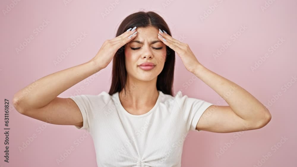 Young caucasian woman suffering for headache over isolated pink background Young caucasian woman suffering for headache over isolated pink background