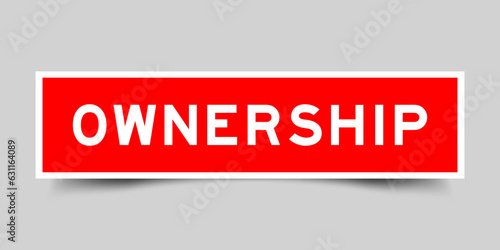 Red color square label sticker with word ownership on gray background