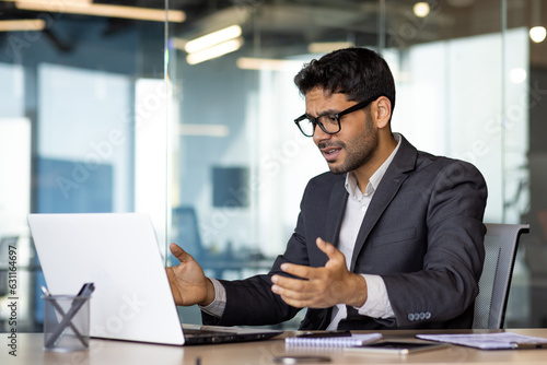 Frustrated and upset hispanic businessman at workplace, man got online rejection error on laptop, unhappy with results inside office in business suit boss.