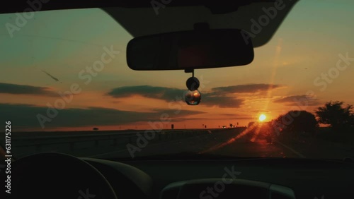 Stunning sunset on horizon through windshield of car. Travel concept