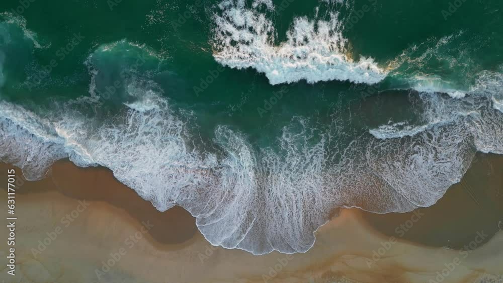 Waves with white foam on sandy shore at sunset. Aerial top down view of sea or ocean sand beach Waves with white foam on sandy shore at sunset. Aerial top down view of sea or ocean sand beach