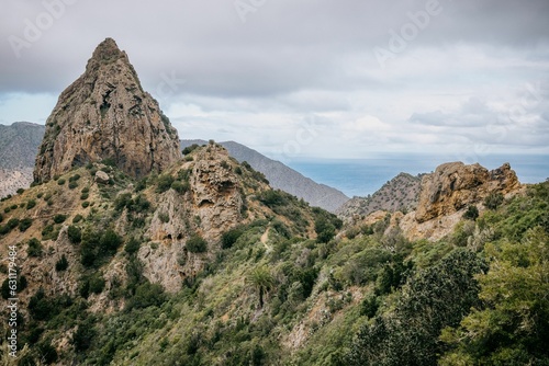 Scenic landscape featuring a mountains in the distance covered with trees and shrubs © David Kertz/Wirestock Creators