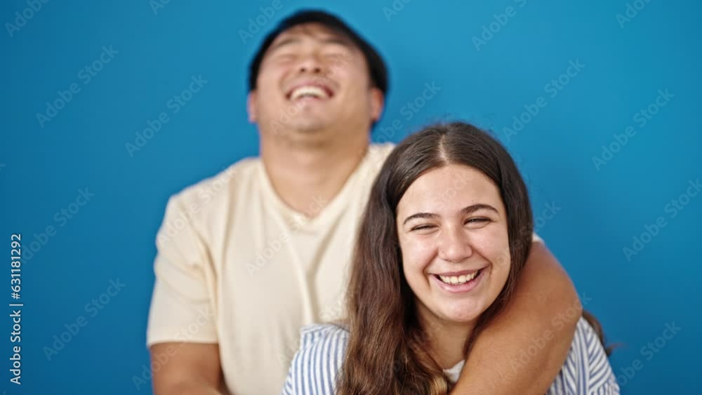 Man and woman couple smiling confident hugging each other over isolated blue background