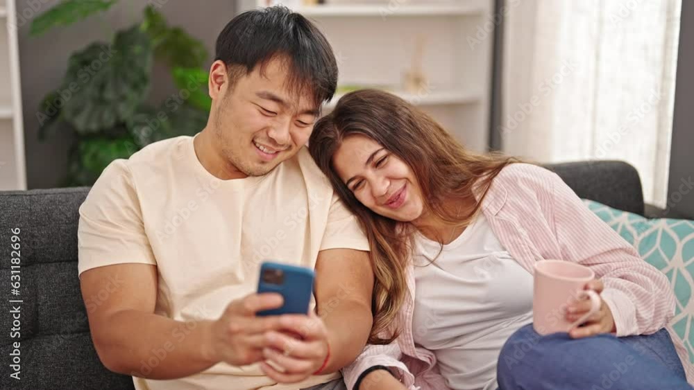 Man and woman couple using smartphone drinking coffee at home Man and woman couple using smartphone drinking coffee at home