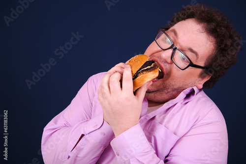 Funny hungry fat man eating burger.