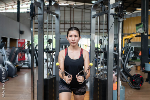 Asian woman exercising Weight training at the gym. Fitness and health care concept.