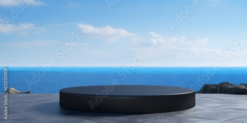 Empty round black podium on stone platform with sea