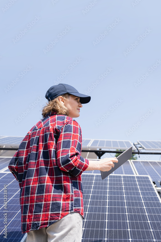 Woman with digital tablet on a background of mobile solar power station