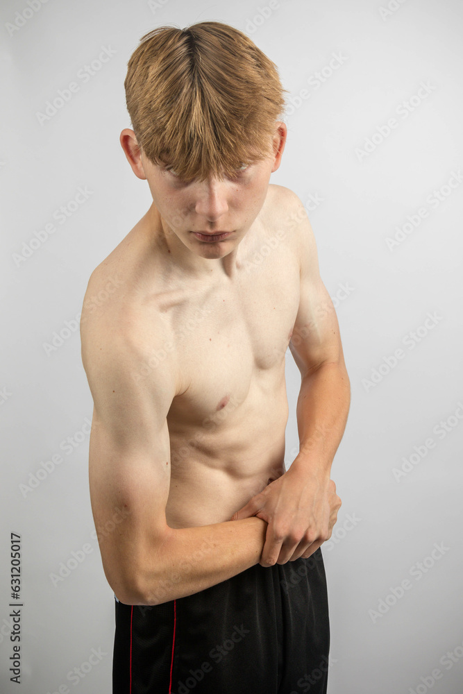 Teenage boy flexing his muscles