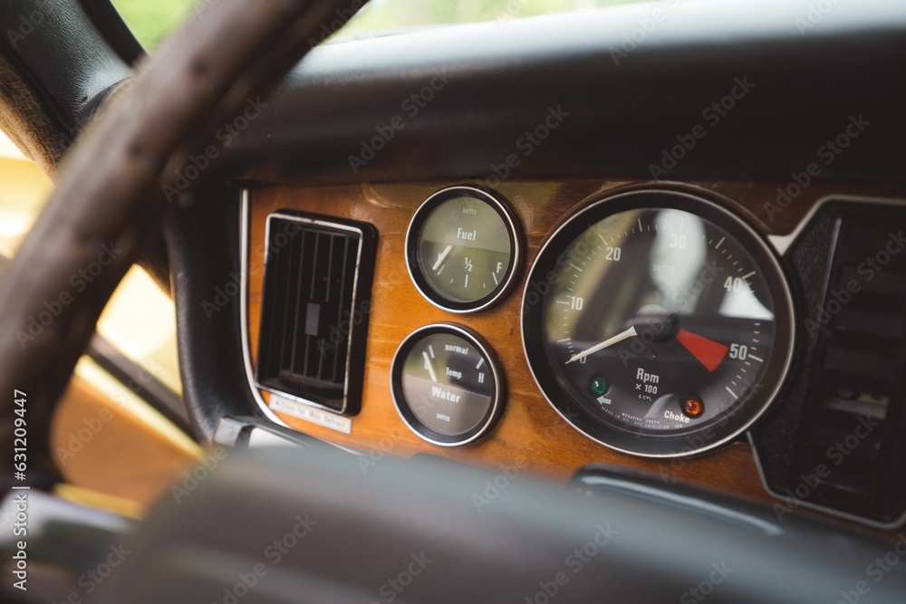 Interior view of a classic car, featuring a dashboard with a variety of dials and gauges