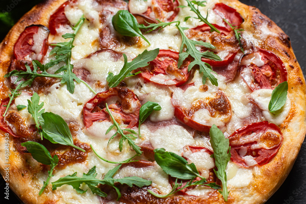 Pizza with ham,tomatoes and mozzarella on a dark background Pizza with ham,tomatoes and mozzarella on a dark background