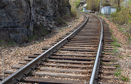 railroad near a rock with shiny rails