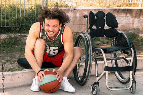 Wheelchair-bound disabled basketball player practicing baskin sports while resting on the sidelines of the court