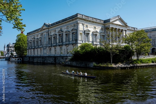 Scenic view of the majestic Appeals Court House in Ghent with people rowing on the water nearby