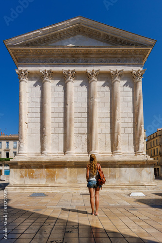 Woman loking at the roman temple Maison carre in Nimes dowtown- Gard, France photo