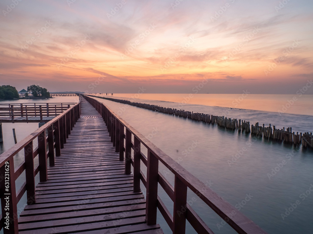 Sea view near mangrove forest with man made wooden barrier for wave protection, under morning twilight colorful sky in Bangkok, Thailand
