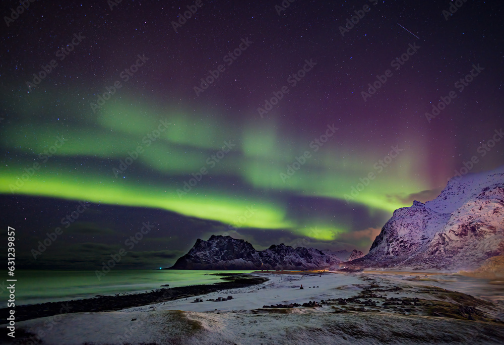 Bright green and magenta colors of the aurora borealis fill the sky in Norway