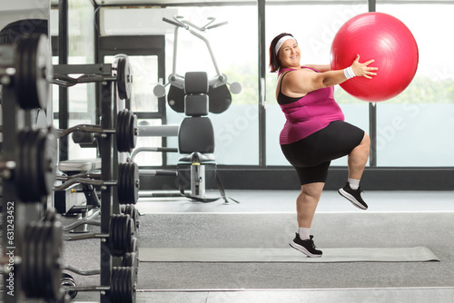 Cheerful overweight woman exercising with a fitness ball