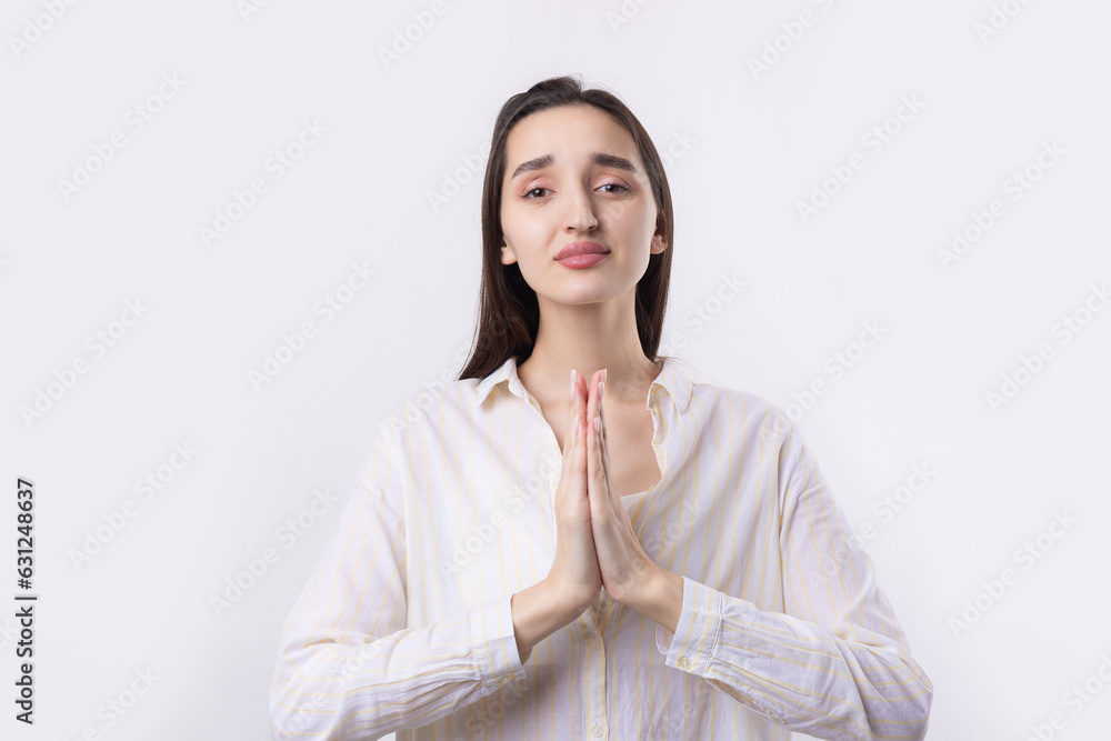 Portrait of a serious young woman showing stop gesture with her palm over white background Portrait of a serious young woman showing stop gesture with her palm over white background
