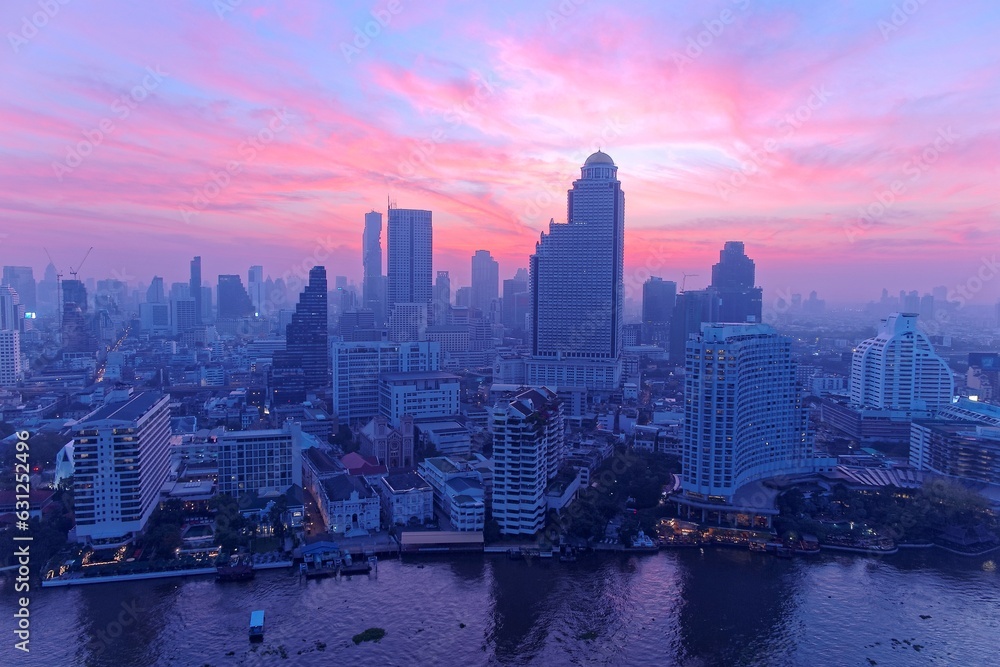 Aerial panorama of Bangkok City in morning twilight, with rosy clouds in the sky, boats & ships on Chao Phraya River & modern skyscrapers by the riverside~Sunrise scenery of Bangkok in bird's eye view