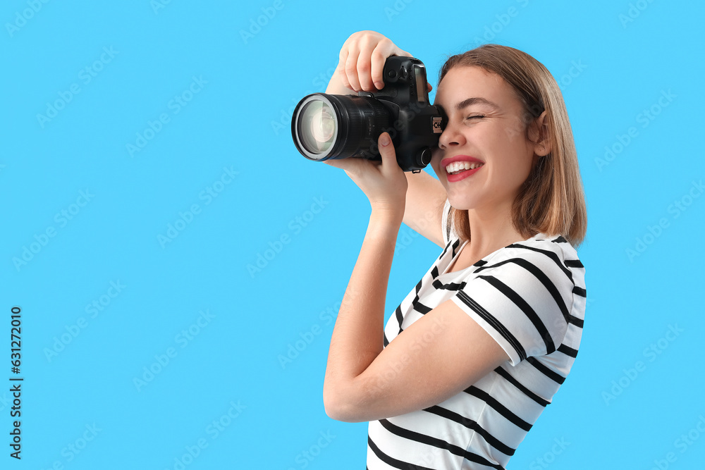 Female photographer with professional camera on blue background Female photographer with professional camera on blue background