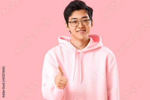 Young Asian man showing thu...