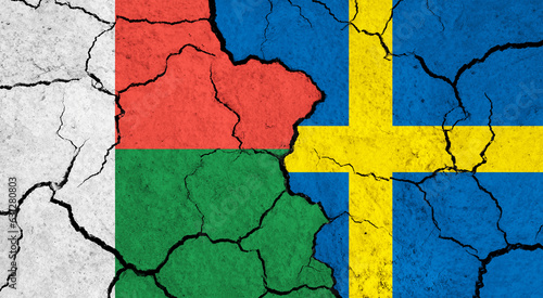 Flags of Madagascar and Sweden on cracked surface - politics, relationship concept