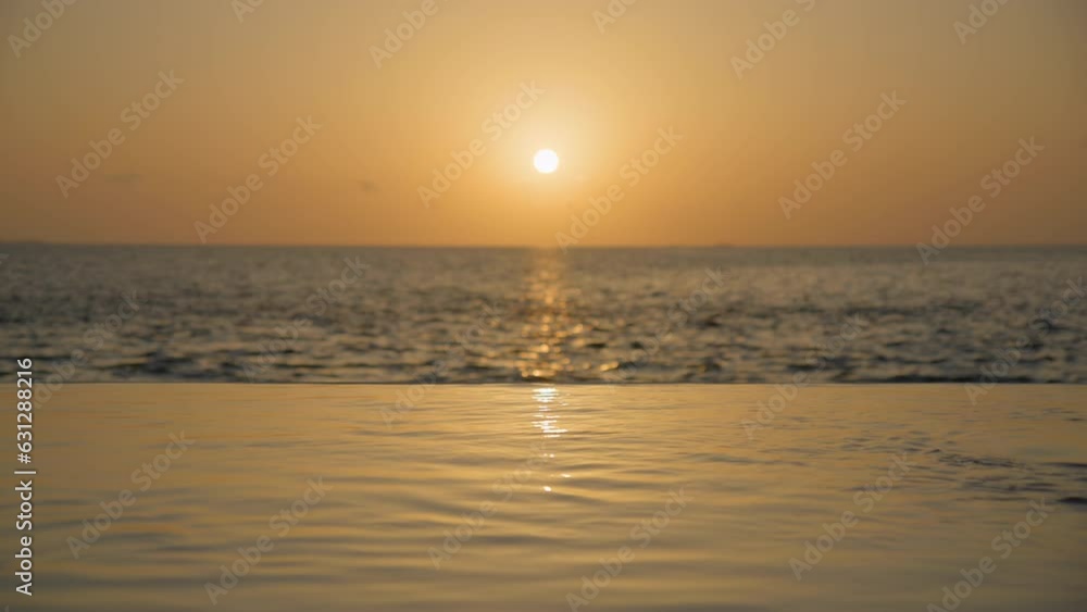 Couple entering private pool at sunset and kissing Couple entering private pool at sunset and kissing