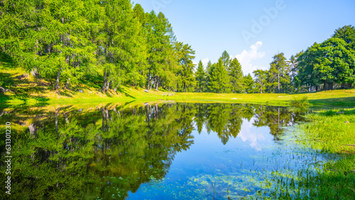 Mountain pond Roccoli Lorla in lush green forest landscape of Bergamo Alps, Italy