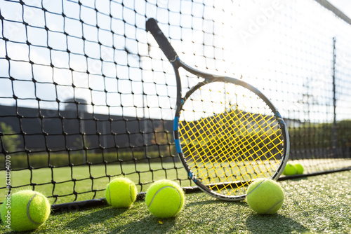 Tennis ball and racket on hard court © Angelov