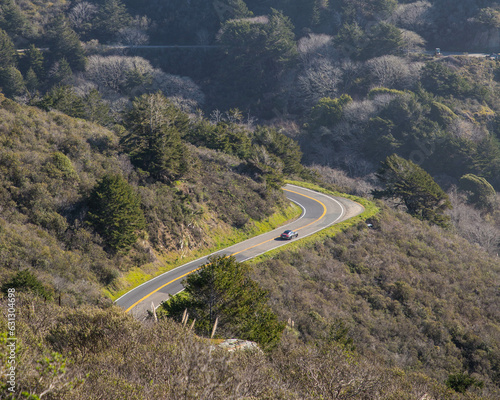 a porsche drives through the mountainous forest of coastal central california 