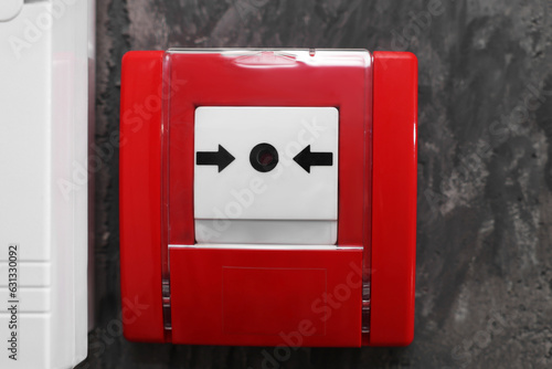 Fotografie Fire alarm push button on grey wall