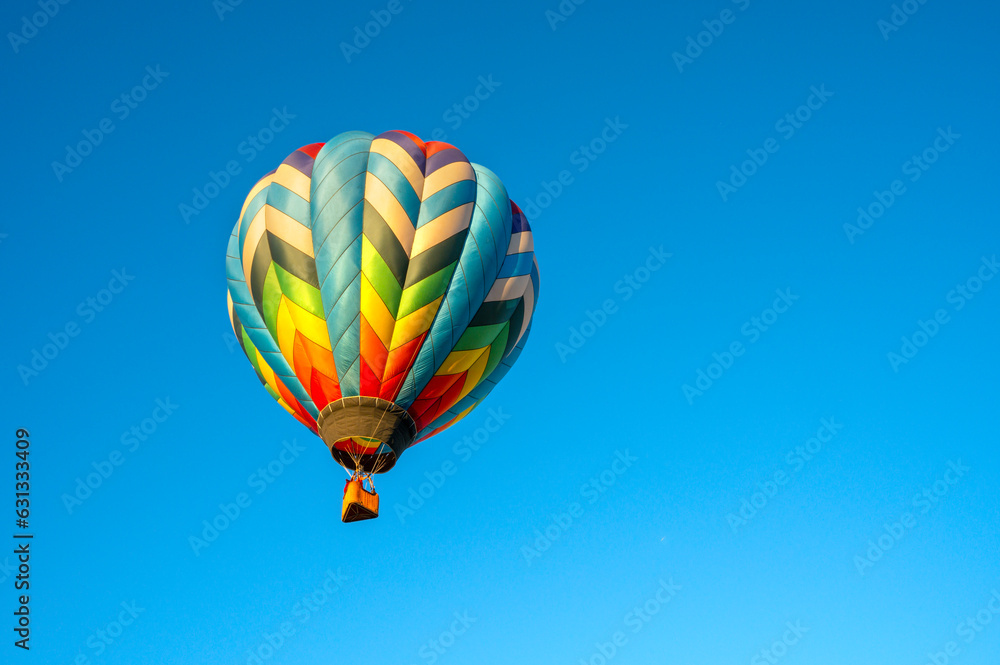 Naklejka premium Flying colorful balloon in bright blue sky, Adirondack, Queensbury, New York