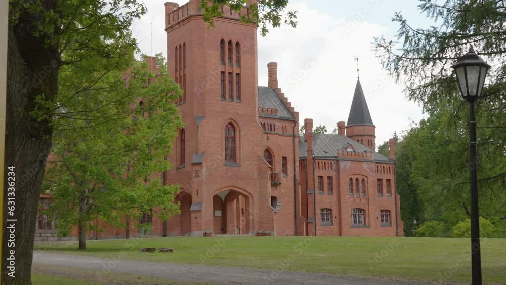 The orange castle in the city on a closer look with the big grassy lawn outside in Estonia The orange castle in the city on a closer look with the big grassy lawn outside in Estonia