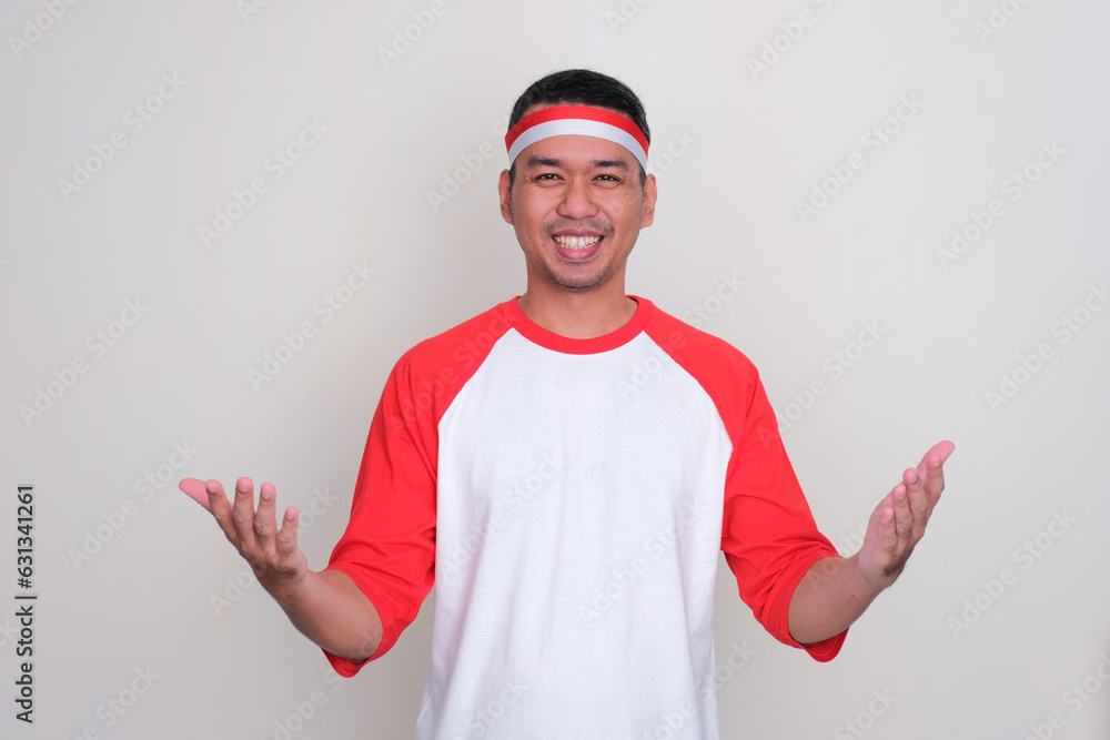 Indonesian man smiling with hands open doing warm greeting Indonesian man smiling with hands open doing warm greeting