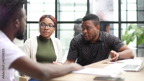 Young modern men in smart casual wear shaking hands and smiling while working in the creative office
