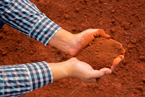 Top view perspective of hands holding the rich red soil, showcasing the essence of the human earth relationship.