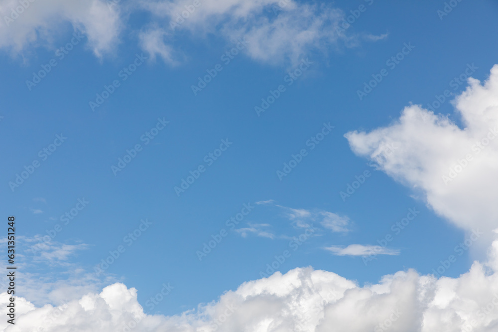 A horizontal shot of bright blue sky with puffy white clouds. A horizontal shot of bright blue sky with puffy white clouds.