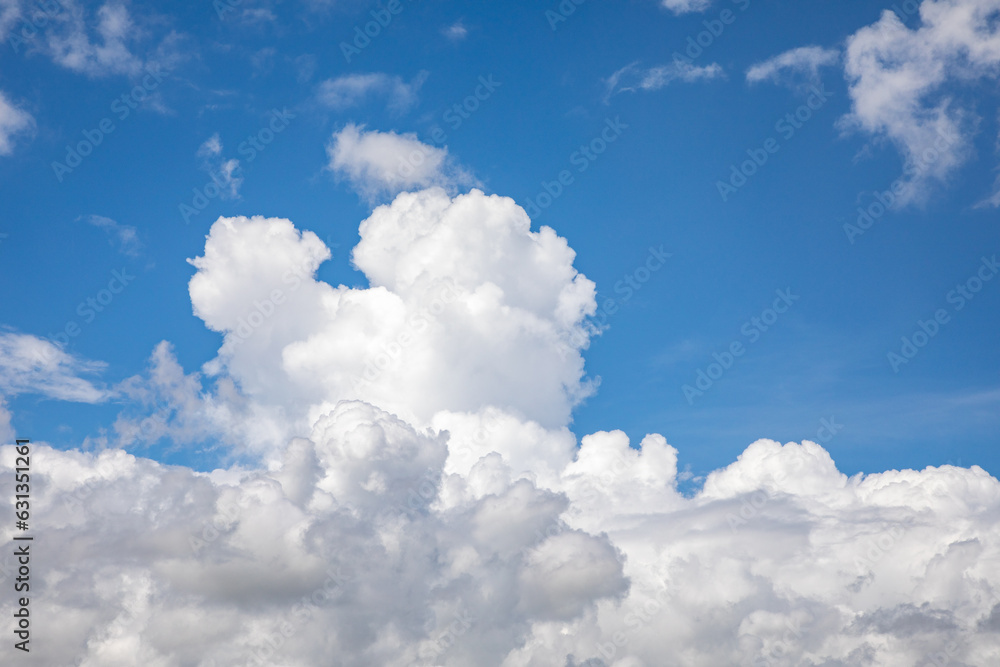A horizontal shot of bright blue sky with puffy white clouds. A horizontal shot of bright blue sky with puffy white clouds.