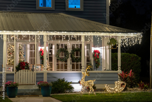 Foto Brightly illuminated christmas decorations on front yard porch of florida family home