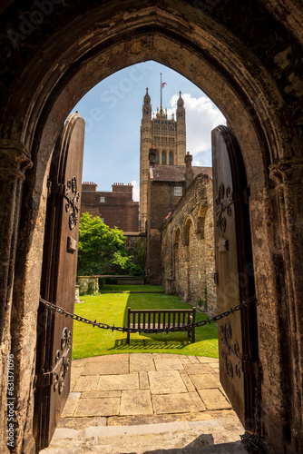 Εκτύπωση καμβά Looking through the old medieval wooden doors and stone archway into a historic brick courtyard with the Palace of Westminster, UK Parliament's Victoria Tower in the background in London, England, UK