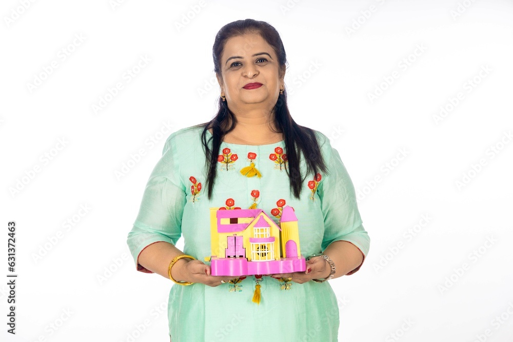 Indian woman holding home toy in hand. real estate concept. Indian woman holding home toy in hand. real estate concept.