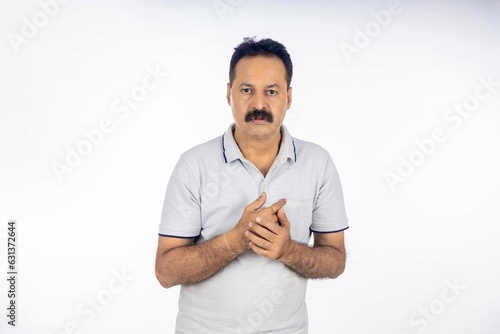 Confident indian man in t shirt standing on white background.