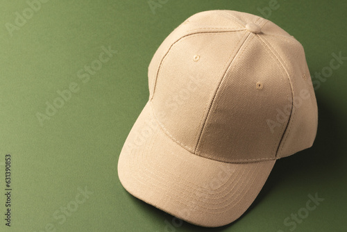 Cream baseball cap and copy space on green background